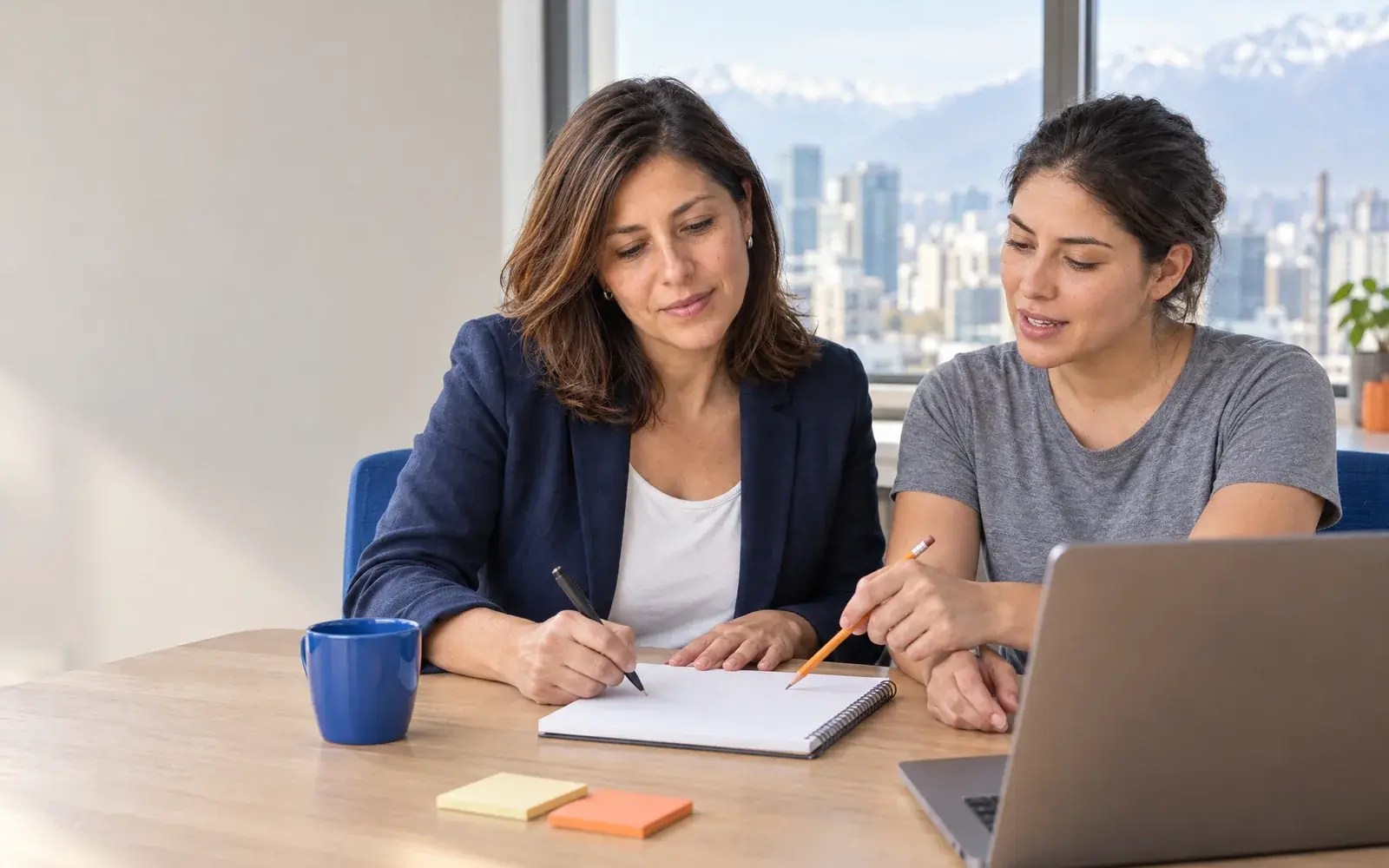 Two people agree on an idea beside a notebook in an office.