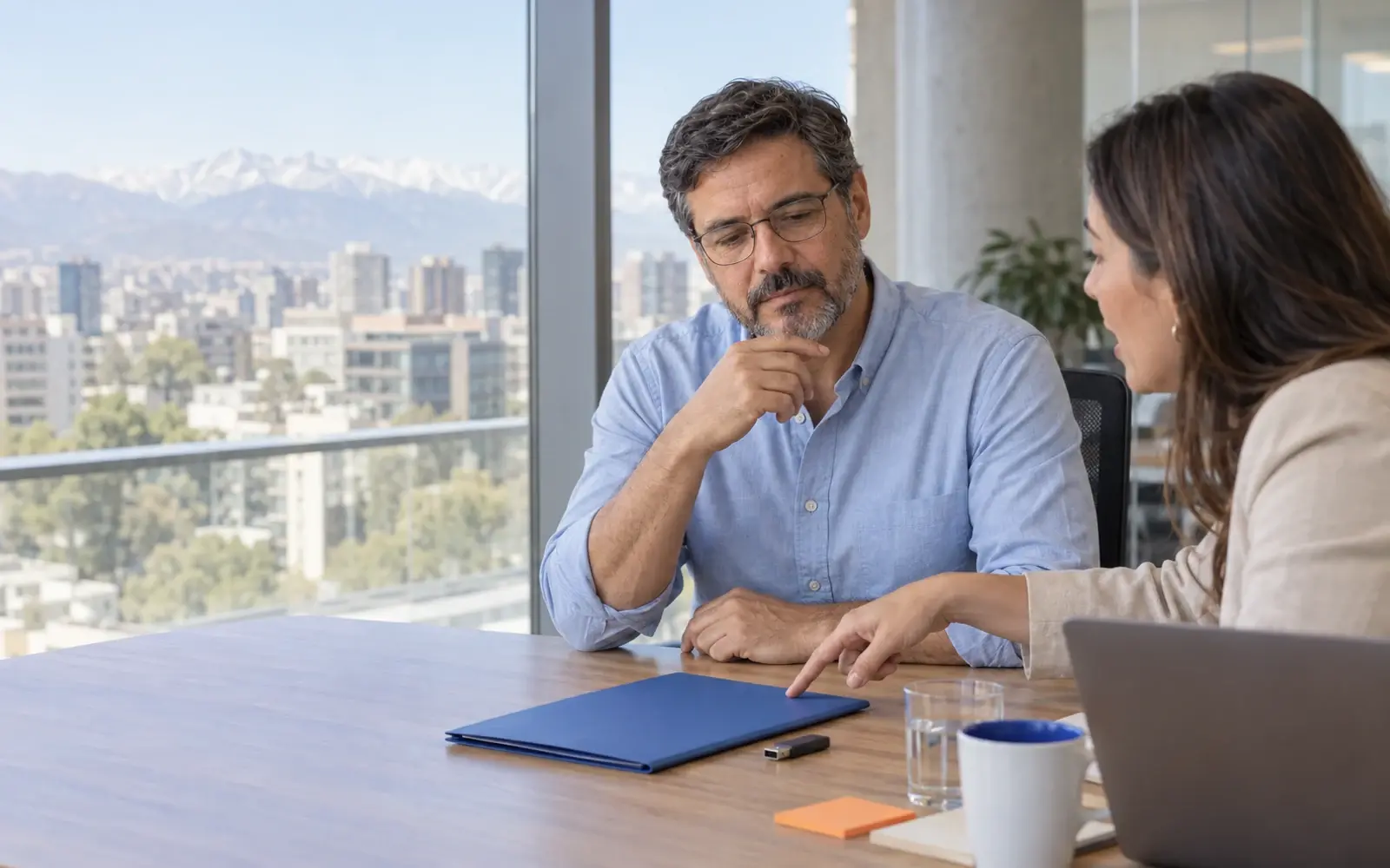 A person receives a folder and a USB drive at a meeting.