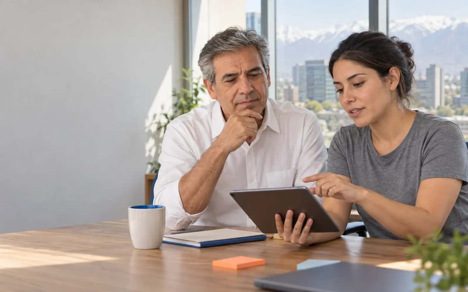 Dos personas comparan opciones en una tablet.