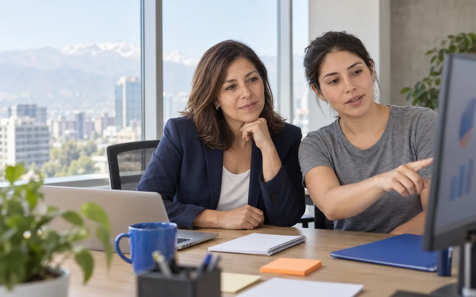 Two people review a report on a blurred screen.